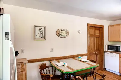 a kitchen with a small table and a refrigerator at 5 Mi to Cooperstown All Star Village Otego Home in Otego