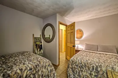 a bedroom with two beds and a mirror at Jewett Cabin with Viewing Deck - 10 Mins to Skiing! in Jewett