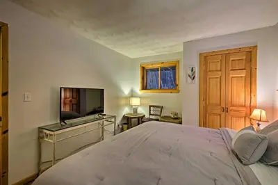a bedroom with a bed and a flat screen tv at Jewett Cabin with Viewing Deck - 10 Mins to Skiing! in Jewett