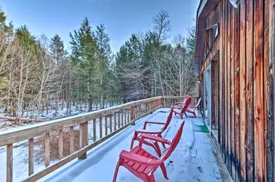 a row of red chairs on a deck with snow on it at Jewett Cabin with Viewing Deck - 10 Mins to Skiing! in Jewett