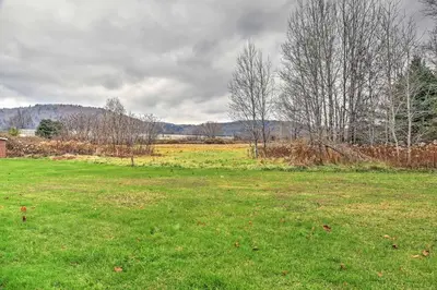 a field with green grass and trees on a cloudy day at Serene Retreat - 7 Mi to All Star Village in Otego