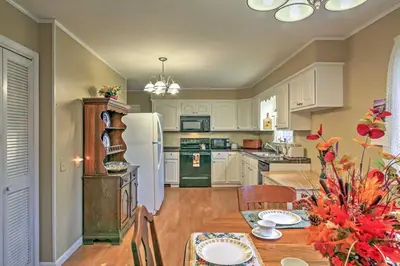 a kitchen with a table and a white refrigerator at Serene Retreat - 7 Mi to All Star Village in Otego