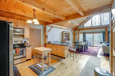 a kitchen with wooden cabinets and a dining room at 1 Mi to Mt Snow Luna Stella Home with Fireplace in West Dover