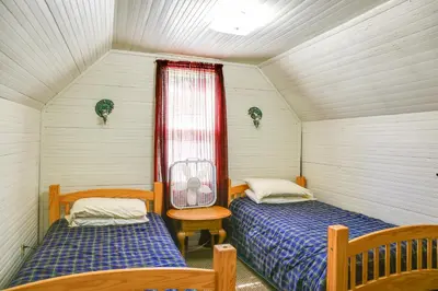 two beds in a small room with a window at Hunter Home with Fire Pit and Yard On Main Street! in Hunter