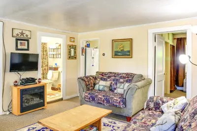 a living room with a couch and a tv at Hunter Home with Fire Pit and Yard On Main Street! in Hunter