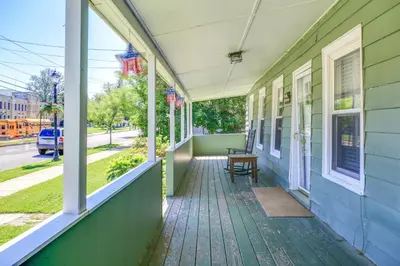 a porch of a house with a bench on it at Hunter Home with Fire Pit and Yard On Main Street! in Hunter