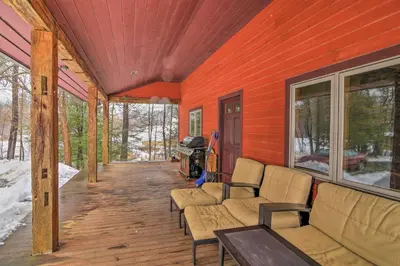 a porch with couches and a stove on a house at Shelburne Studio Cabin with Spring-Fed Pool! in Shelburne