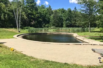 a pond in the middle of a park at Shelburne Studio Cabin with Spring-Fed Pool! in Shelburne