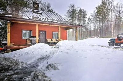 a house with a pile of snow in front of it at Shelburne Studio Cabin with Spring-Fed Pool! in Shelburne
