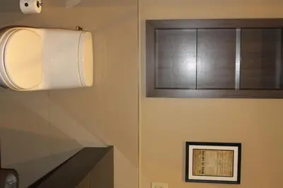 a bathroom with a toilet paper dispenser and a window at Opera House Hotel in Bronx