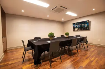 a conference room with a black table and chairs at Opera House Hotel in Bronx
