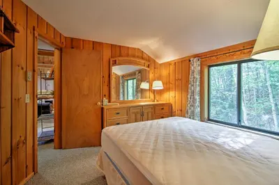 a bedroom with a bed and a large window at Spacious Home Adjacent to Mt Snow with Game Room! in West Dover