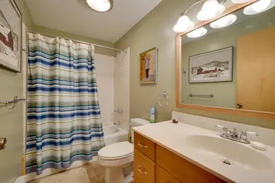 a bathroom with a sink and a toilet and a mirror at Spacious Home Adjacent to Mt Snow with Game Room! in West Dover