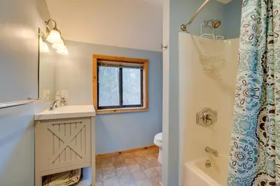 a bathroom with a sink and a toilet and a window at Spacious Home Adjacent to Mt Snow with Game Room! in West Dover