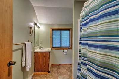 a bathroom with a sink and a shower curtain at Spacious Home Adjacent to Mt Snow with Game Room! in West Dover