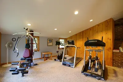 a gym with several tread machines in a room at Spacious Home Adjacent to Mt Snow with Game Room! in West Dover