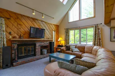 a living room with a couch and a fireplace at Spacious Home Adjacent to Mt Snow with Game Room! in West Dover