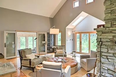a living room filled with furniture and a stone wall at Berkshires Home on 11 Acres with Pond and 2 Fire Pits! in Becket