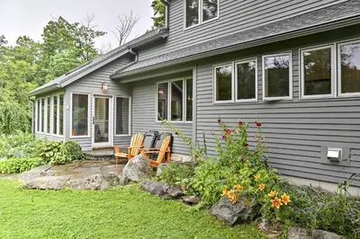 a house with two chairs and a table in the yard at Berkshires Home on 11 Acres with Pond and 2 Fire Pits! in Becket