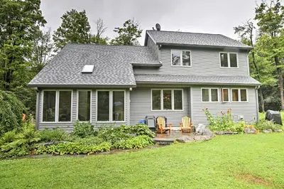 a gray house with a patio and a yard at Berkshires Home on 11 Acres with Pond and 2 Fire Pits! in Becket