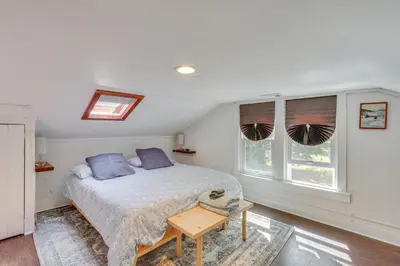 a bedroom with a bed and two windows at UpdatedandPet-Friendly Cabin By Hikes and Woodstock! in Bearsville