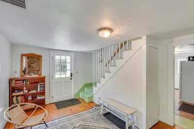 a home with white walls and a staircase with a bench at UpdatedandPet-Friendly Cabin By Hikes and Woodstock! in Bearsville