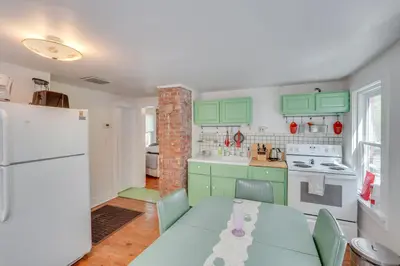 a kitchen with green cabinets and a table and a refrigerator at UpdatedandPet-Friendly Cabin By Hikes and Woodstock! in Bearsville
