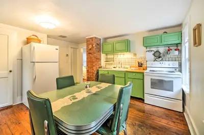 a kitchen with green cabinets and a table with chairs at UpdatedandPet-Friendly Cabin By Hikes and Woodstock! in Bearsville