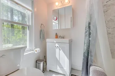 a bathroom with a toilet and a sink and a window at UpdatedandPet-Friendly Cabin By Hikes and Woodstock! in Bearsville