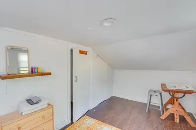 a white room with a table and a stool at UpdatedandPet-Friendly Cabin By Hikes and Woodstock! in Bearsville