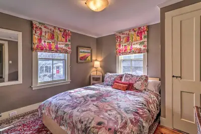 a bedroom with a bed and two windows at Cozy Litchfield House with Fenced-In Yard and Fire Pit in Litchfield