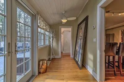 a hallway with large windows and a hallway with wooden floors at Cozy Litchfield House with Fenced-In Yard and Fire Pit in Litchfield