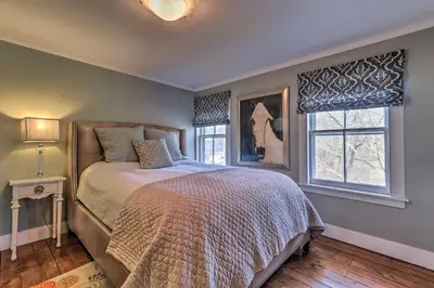 a bedroom with a bed and two windows at Cozy Litchfield House with Fenced-In Yard and Fire Pit in Litchfield