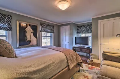 a bedroom with a large bed and a television at Cozy Litchfield House with Fenced-In Yard and Fire Pit in Litchfield