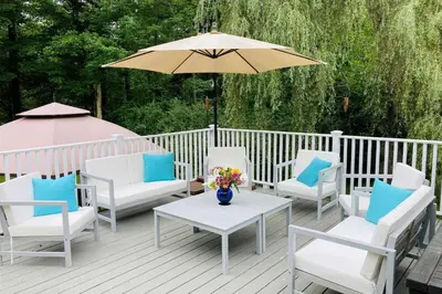 a deck with chairs and a table with an umbrella at Cozy Litchfield House with Fenced-In Yard and Fire Pit in Litchfield