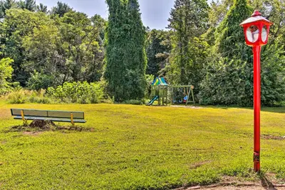 a park with a bench and a red street light at Cozy Agawam Studio with Yard 2 Miles to Six Flags! in Agawam