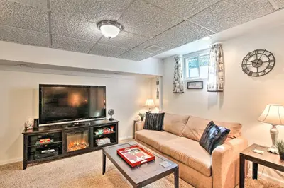 a living room with a couch and a flat screen tv at Cozy Agawam Studio with Yard 2 Miles to Six Flags! in Agawam