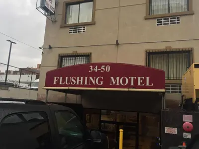 a building with a sign for a flisting motel at Flushing Motel in Queens