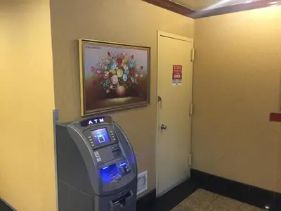 a video game machine in a room with a painting on the wall at Flushing Motel in Queens