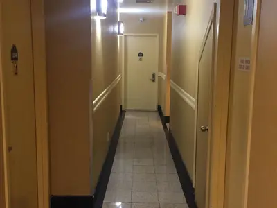 a hallway in a hospital with two doors and a tile floor at Flushing Motel in Queens