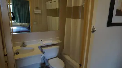 a bathroom with a sink and a toilet and a mirror at Flushing Motel in Queens