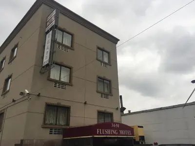 a building with a sign on the side of it at Flushing Motel in Queens