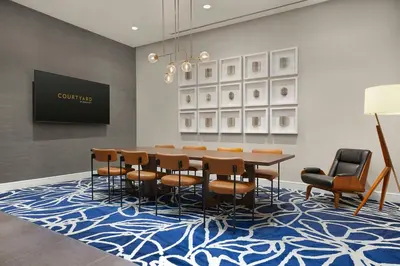 a dining room with a table and chairs on a blue rug at Courtyard by Marriott New York Manhattan/Chelsea in New York