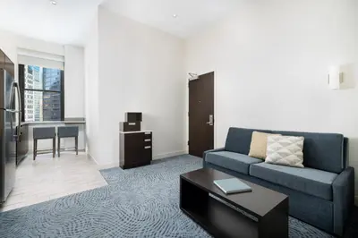 a living room with a blue couch and a table at Residence Inn by Marriott New York Downtown Manhattan/World Trade Center Area in New York
