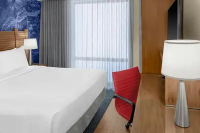 a hotel room with a bed and a red chair at Fairfield Inn by Marriott New York Manhattan/Financial District in New York