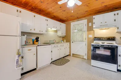 a kitchen with white appliances and a wooden ceiling at Near Hiking and Skiing Home in Wilmington! in Wilmington