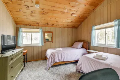 a bedroom with two beds and a tv and two windows at Near Hiking and Skiing Home in Wilmington! in Wilmington