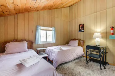 a bedroom with two beds and a chair and a window at Near Hiking and Skiing Home in Wilmington! in Wilmington