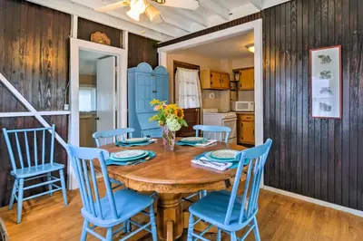 a dining room with a wooden table and blue chairs at Beachfront Connecticut Retreat with Views! in Milford