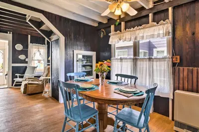 a dining room with a wooden table and blue chairs at Beachfront Connecticut Retreat with Views! in Milford